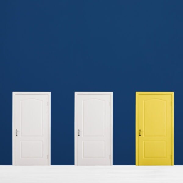 Yellow door among white ones in room. Concept of choice